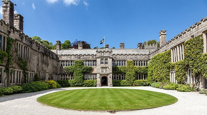 Lanhydrock house and lawn with a bright blue sky